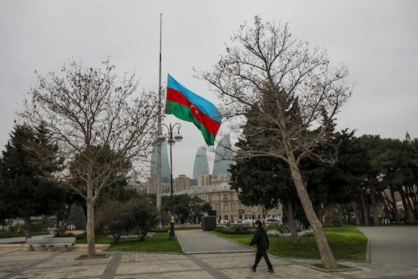 Azerbaijan's national flag at half-mast in the memory of victims of the Azerbaijan Airlines' Embraer 190 that crashed near the Kazakhstan's airport of Aktau, is seen in the center of Baku, Azerbaijan, Thursday, Dec. 26, 2024. (AP Photo/Aziz Karimov)