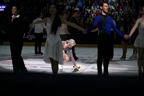 A skater places flowers on the ice Sunday, March 2, 2025, in Washington, at the Legacy on Ice event, a figure skating tribute to support the families and loved ones affected by the Jan. 29 aviation incident. (AP Photo/Nick Wass)