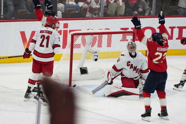 The puck gets past Carolina Hurricanes goaltender Pyotr Kochetkov, center, on a goal scored by Florida Panthers' Aleksander Barkov during the third period in Game 3 of the NHL hockey Stanley Cup Eastern Conference finals Saturday, May 24, 2025, in Sunrise, Fla. (AP Photo/Lynne Sladky)