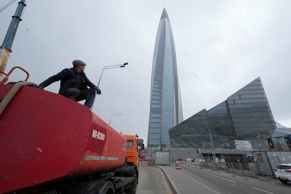 FILE - A worker sits on his water tank truck next to the business tower Lakhta Centre, the headquarters of Russian gas monopoly Gazprom in St. Petersburg, Russia, April 27, 2022. (AP Photo/Dmitri Lovetsky, File)