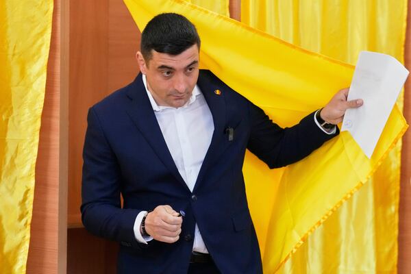 Presidential candidate George Simion exits a voting cabin before casting his vote in the first round of the presidential election redo in Mogosoaia, Romania, Sunday, May 4, 2025. (AP Photo/Vadim Ghirda)