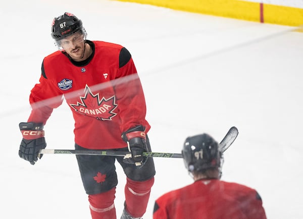 Canada's Sidney Crosby skates in to speak with teammate Connor McDavid during 4 Nations Face-Off hockey practice in Montreal on Monday, Feb. 10, 2025. Canada will face Sweden on Feb. 12. (Christinne Muschi/The Canadian Press via AP)