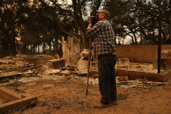 Paul Perri searches through his daughter's fire-ravaged property in the aftermath of the Eaton Fire on Thursday, Jan. 9, 2025, in Altadena, Calif. (AP Photo/Eric Thayer)