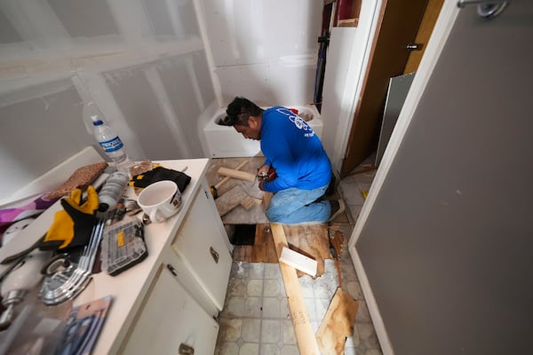 Mario Mendoza works on repairing a mobile home in Belle Chasse, La., Wednesday, Jan. 15, 2025, that was damaged from Hurricane Ida in 2021. (AP Photo/Gerald Herbert)