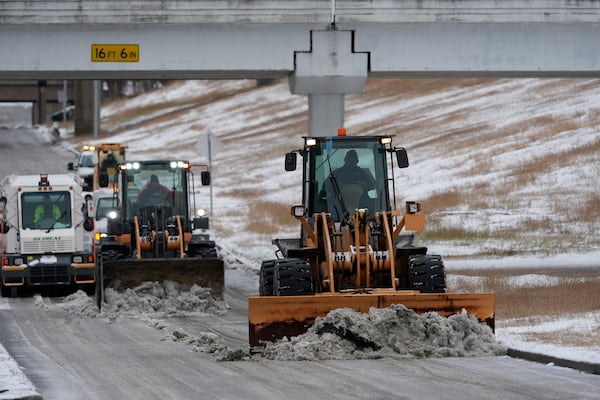 Workers plow snow off the roadways at the closed George Bush Intercontinental Airport Tuesday, Jan. 21, 2025, in Houston. (AP Photo/David J. Phillip)