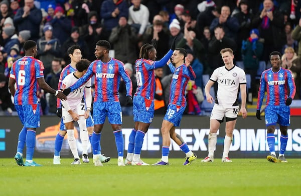 Crystal Palace's Eberechi Eze, center celebrates scoring his side's first goal of the game with teammate Daniel Munoz during the English FA Cup third round soccer match between Crystal Palace and Stockport County at Selhurst Park, London, Sunday, Jan. 12, 2025. (Zac Goodwin/PA via AP)