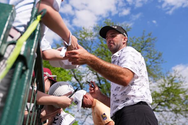 Denny McCarthy signs autographs for fans after finishing the first round of the Truist Championship golf tournament at the Philadelphia Cricket Club, Thursday, May 8, 2025, in Flourtown, Pa. (AP Photo/Matt Rourke)