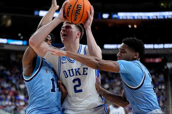 Duke forward Cooper Flagg drives to the basket between Mount St. Mary's forward Jedy Cordilia, left, and guard Arlandus Keyes during the first half in the first round of the NCAA college basketball tournament, Friday, March 21, 2025, in Raleigh, N.C. (AP Photo/Chris Carlson)