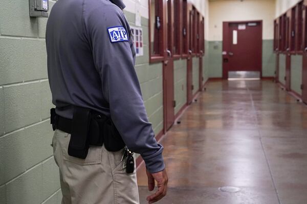 FILE - A security guard poses for a photo next to the group holding cells during a media tour of the Port Isabel Detention Center (PIDC), hosted by U.S. Immigration and Customs Enforcement (ICE) and Harlingen Enforcement and Removal Operations (ERO) in Los Fresnos, Texas, June 10, 2024. (Veronica Gabriela Cardenas/Pool Photo via AP, File)