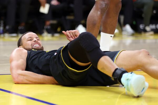 Golden State Warriors' Stephen Curry grimaces in pain after a rough landing in the 3rd quarter against Toronto Raptors during NBA game at Chase Center in San Francisco on Thursday, March 20, 2025.(Scott Strazzante/San Francisco Chronicle via AP)