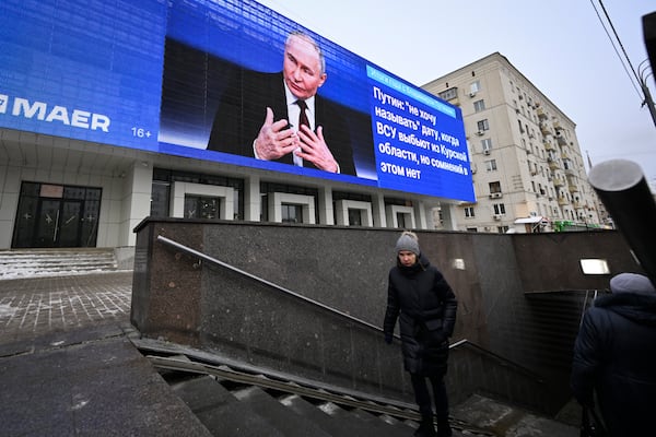 An electronic billboard on a building shows Russian President Vladimir Putin giving his annual news conference and call-in show in Moscow, Russia, Thursday, Dec. 19, 2024. (AP Photo/Dmitry Serebryakov)