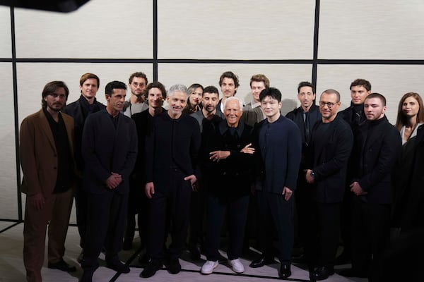 Giorgio Armani poses with guests and actors at the end of the men's Giorgio Armani Fall-Winter 2025-2026 collection, that was presented in Milan, Italy, Monday, Jan. 20, 2025. (AP Photo/Antonio Calanni)