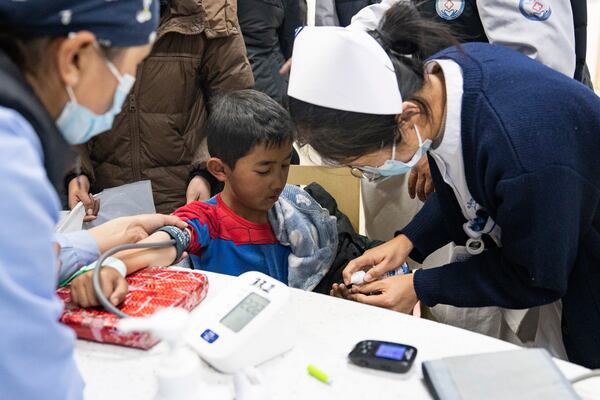 In this photo released by Xinhua News Agency, medical workers attend to an injured child in the aftermath of an earthquake at the Xigaze People's Hospital in Xigaze City, southwest China's Tibet Autonomous Region, Wednesday Jan. 8, 2025. (Tenzin Nyida/Xinhua via AP)