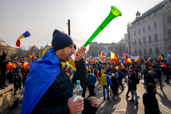 A protester blows into a vuvuzela during a rally organized by the right wing Alliance for the Unity of Romanians (AUR), calling for free elections after Romania' s Constitutional Court annulled the first round of presidential elections last December, in Bucharest, Romania, Sunday, Jan. 12, 2025. (AP Photo/Vadim Ghirda)