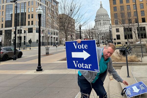 Election worker Mike Quieto with the city of Madison puts out voting signs near the state Capitol ahead of polls opening for the first day of early voting in the race for state Supreme Court on Tuesday, March 18, 2025, in Madison, Wis. (AP Photo/Scott Bauer)