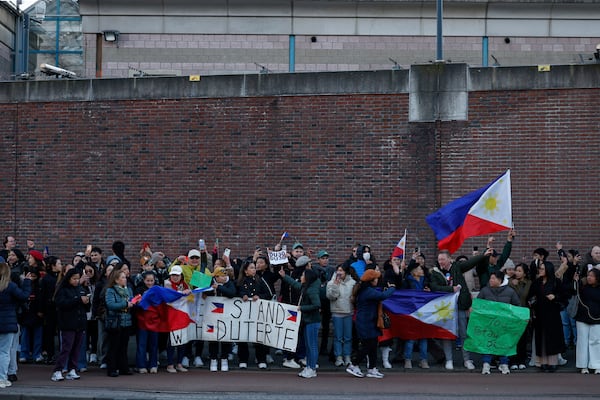 Supporters of former Philippine President Rodrigo Duterte hold flags and banners during a demonstration outside the International Criminal Court detention center near The Hague in Scheveningen, Netherlands, Wednesday, March 12, 2025. (AP Photo/Omar Havana)