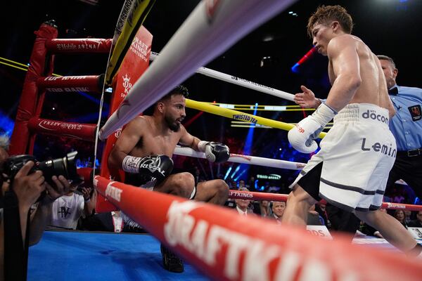 Naoya Inoue, right, knocks down Ramon Cardenas in a junior featherweight title boxing match Sunday, May 4, 2025, in Las Vegas. (AP Photo/John Locher)