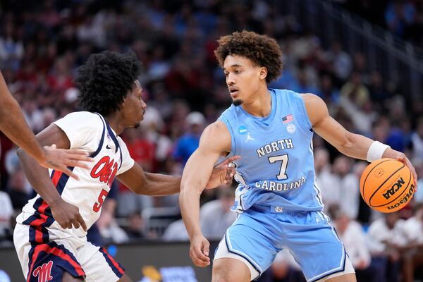 North Carolina guard Seth Trimble (7) handles the ball against Mississippi guard Jaylen Murray (5) during the second half in the first round of the NCAA college basketball tournament, Friday, March 21, 2025, in Milwaukee. (AP Photo/Kayla Wolf)