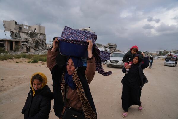 Displaced Palestinians, carrying their belongings, move away from the areas where the Israeli army is operating after Israel's renewed offensive in the Gaza Strip, on the outskirts of Beit Lahia, Thursday, March 20, 2025. (AP Photo/Jehad Alshrafi)