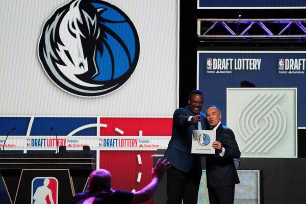 Dallas Mavericks' Rolando Blackman, left, and NBA Deputy Commissioner Mark Tatum, right, pose for photos after Tatum announced that the Mavericks had won the first pick in the NBA basketball draft lottery in Chicago, Monday, May 12, 2025. (AP Photo/Nam Y. Huh)