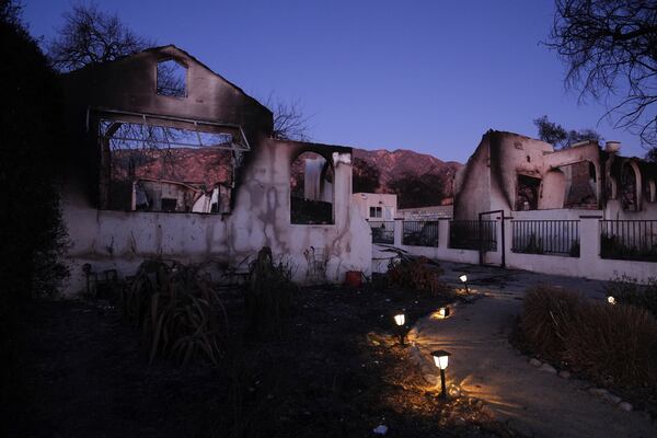 Solar lights remain on outside a home destroyed by the Eaton Fire, Tuesday, Jan. 14, 2025, in Altadena, Calif. (AP Photo/Jae C. Hong)