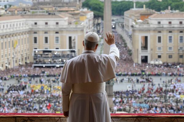 Pope Leo XIV waives from the central balcony of St. Peter's Basilica overlooking St. Peter's Square where tens of thousands of faithful gathered at noon to receive the first traditional Sunday blessing after his election on Thursday and to pray the Regina Caeli, Sunday, May 11, 2025. (Vatican Media via AP)