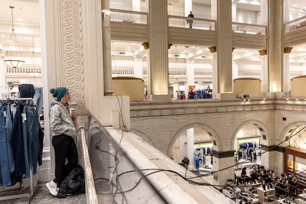 Catherine Northington, 34, of Center City, Pa., listens to the Wanamaker Organ, Friday, Jan. 10, 2025, in Philadelphia, as they heard that the store was closing. (Tyger Williams/The Philadelphia Inquirer via AP)