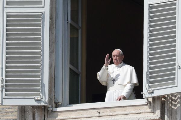 FILE - Pope Francis delivers his blessing from the window of his private library overlooking St. Peter's Square, at the Vatican, March 22, 2020. (AP Photo/Andrew Medichini, File)