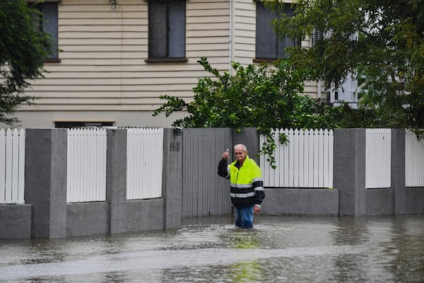 Resident Bruce Maddox walks back through flood waters to his home in the Brisbane suburb of Oxley, Australia, Monday, March 10, 2025. (Jono Searle/AAP Image via AP)