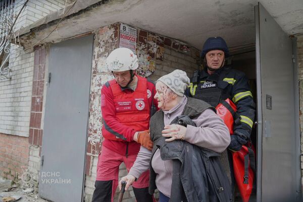 In this photo provided by the Ukrainian Emergency Service, a paramedic evacuates an elderly resident whose house was hit by Russian attack in Sumy, Ukraine, Tuesday, March 25, 2025. (Ukrainian Emergency Service via AP)