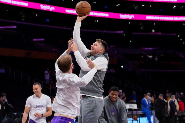 Los Angeles Lakers guard Luka Doncic, center right, warms up before an NBA basketball game against the Dallas Mavericks, Tuesday, Feb. 25, 2025, in Los Angeles. (AP Photo/Mark J. Terrill)