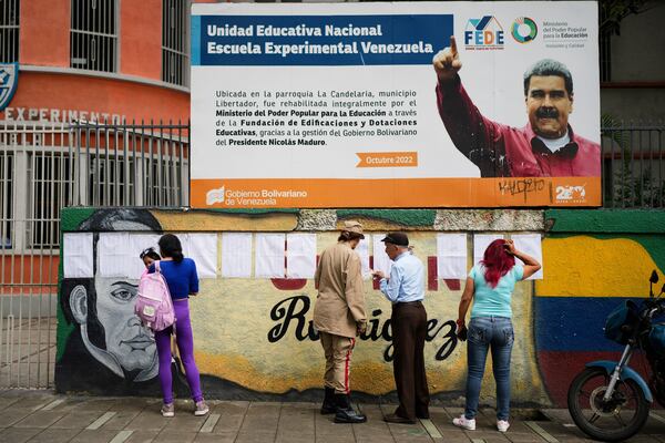 Voters look at the rolls at a polling station during legislative and local elections in Caracas, Venezuela, Sunday, May 25, 2025. (AP Photo/Ariana Cubillos)