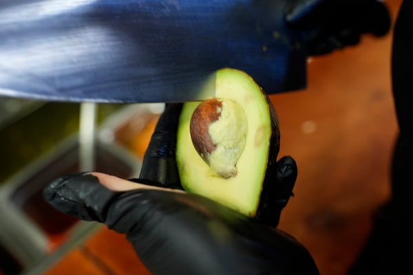 An avocado is cut at the Birrieria Chalio Mexican Restaurant in Fort Worth, Texas, Thursday, Feb. 13, 2025. (AP Photo/LM Otero)