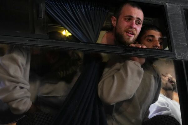 Freed Palestinian prisoners look from a bus window as they arrive in the Gaza Strip after being released from an Israeli prison following a ceasefire agreement between Hamas and Israel in Khan Younis, Gaza Strip, Thursday, Feb. 27, 2025. (AP Photo/Abdel Kareem Hana)