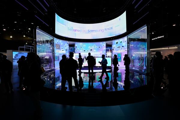 People look at a display of Samsung screens and products at the CES tech show Tuesday, Jan. 7, 2025, in Las Vegas. (AP Photo/Abbie Parr)