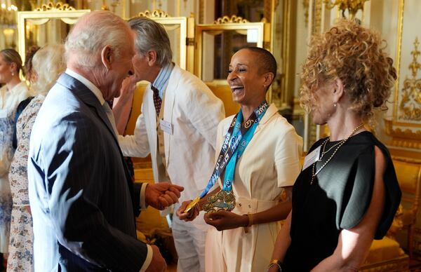 Britain's King Charles III speaks with broadcaster Adele Roberts during a reception in Buckingham Palace, London, in celebration of community-based initiatives raising awareness about cancer and supporting those living with cancer, Wednesday April 30, 2025. (Andrew Matthews/Pool Photo via AP)