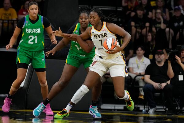 Indiana Fever center Aliyah Boston (7) drives around Brazil forward Licinara Bispo, second from left, during the first half of an exhibition women's basketball game, Sunday, May 4, 2025, in Iowa City, Iowa. (AP Photo/Charlie Neibergall)