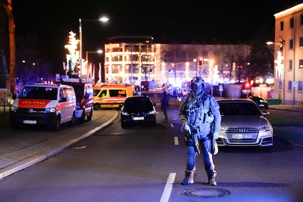 Police officers guard at a blocked road near a Christmas market after an incident in Magdeburg, Germany, Friday, Dec. 20, 2024. (AP Photo/Ebrahim Noroozi)