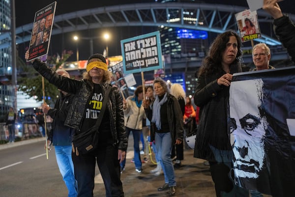 Israelis protest against Prime Minister Benjamin Netanyahu's government and call for the release of hostages, held in the Gaza Strip by the Hamas militant group, in Tel Aviv, Israel, Monday, Jan. 6, 2025. (AP Photo/Ohad Zwigenberg)