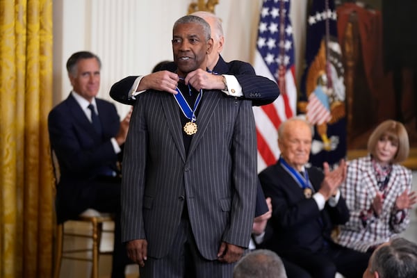 President Joe Biden, right, presents the Presidential Medal of Freedom, the Nation's highest civilian honor, to Denzel Washington in the East Room of the White House, Saturday, Jan. 4, 2025, in Washington. (AP Photo/Manuel Balce Ceneta)