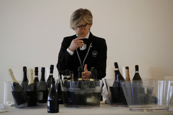 A sommelier opens Prosecco bottles during a wine testing in Asolo, Italy, Monday, Oct. 15, 2018. Global sales of prosecco the smooth, drinkable sparkling wine rooted in the northeastern hills of Italy are booming, and champagne, the original bubbly, is taking note. (AP Photo/Luca Bruno, File)