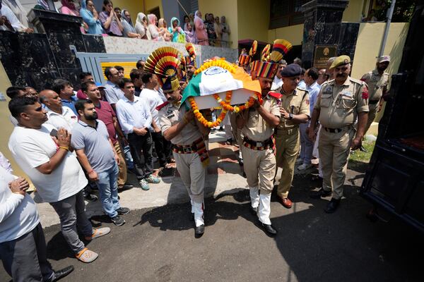 Police personnel carry the casket containing the body of Raj Thapa, a senior bureaucrat who was killed in Pakistani shelling in Rajouri, at his funeral in Jammu, India, Sunday, May 11, 2025. (AP Photo/Channi Anand)