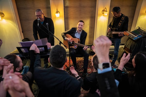 Chairman of Demokraatit, Jens-Frederik Nielsen, center, plays guitar as he reacts during the election party at Demokraatit by cafe Killut in Nuuk, early Wednesday, March 12, 2025. (Mads Claus Rasmussen/Ritzau Scanpix via AP)