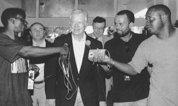 FILE - Former U.S. President Jimmy Carter talks with the press upon his arrival in Georgetown, Guyana, Oct. 3, 1992, to monitor the elections on Oct. 5. (AP Photo/Diego Giudice, File)