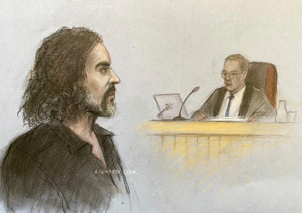 This court artist drawing by Elizabeth Cook shows Russell Brand appearing in the dock at Westminster Magistrates' Court, London, Friday, May 2, 2025, where he is charged with with one count each of rape, indecent assault and oral rape, as well as two counts of sexual assault, relating to four separate women. (Elizabeth Cook/PA via AP)