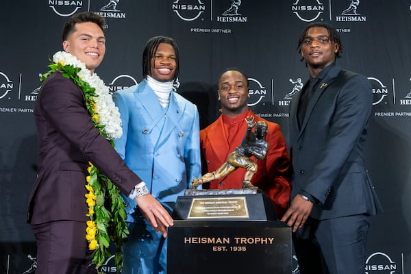 Heisman Trophy finalists, from left, Oregon's Dillon Gabriel, Colorado's Travis Hunter, Boise State's Ashton Jeanty and Miami's Cam Ward pose with the trophy during a college football press conference, Saturday, Dec. 14, 2024, in New York. (AP Photo/Corey Sipkin)