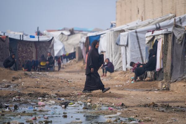 A woman walk at a tent camp for displaced Palestinians in Deir al-Balah, central Gaza Strip, Thursday Jan. 16, 2025. (AP Photo/Abdel Kareem Hana)