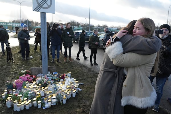 People gather at a makeshift memorial near the scene of a shooting on the outskirts of Orebro, Sweden, Wednesday, Feb. 5, 2025. (AP Photo/Sergei Grits)