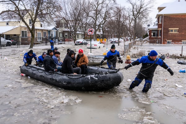 Members of the Southeast Michigan Dive Team pull people to safety after a water main break in Detroit caused massive flooding, triggering evacuations, Monday, Feb. 17, 2025. (Andy Morrison/Detroit News via AP)