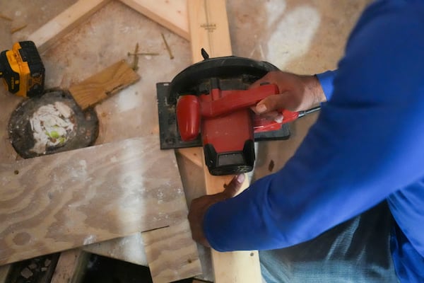 Mario Mendoza works on repairing a mobile home in Belle Chasse, La., Wednesday, Jan. 15, 2025, that was damaged from Hurricane Ida in 2021. (AP Photo/Gerald Herbert)